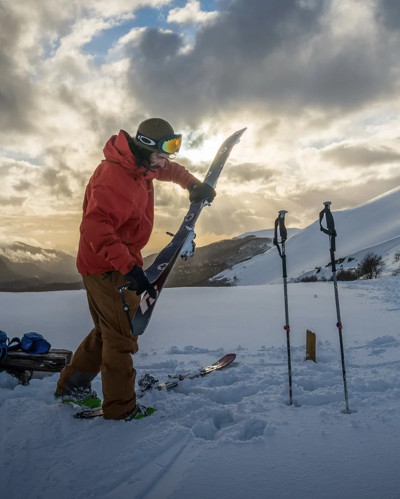 Esquiador acomodando sus esquís en la nieve